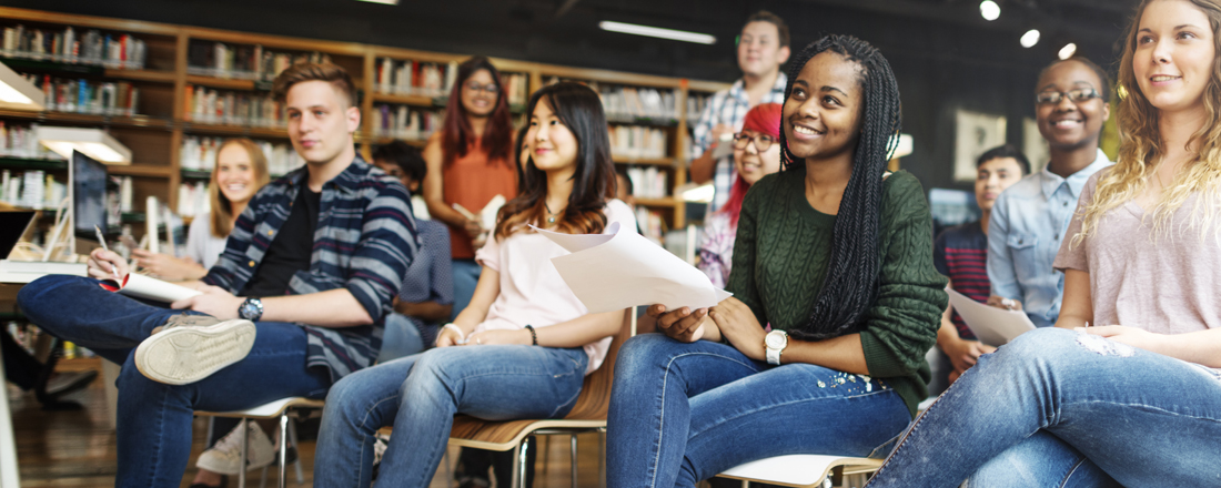 Internationale Studierende sitzen in einer Bibliothek